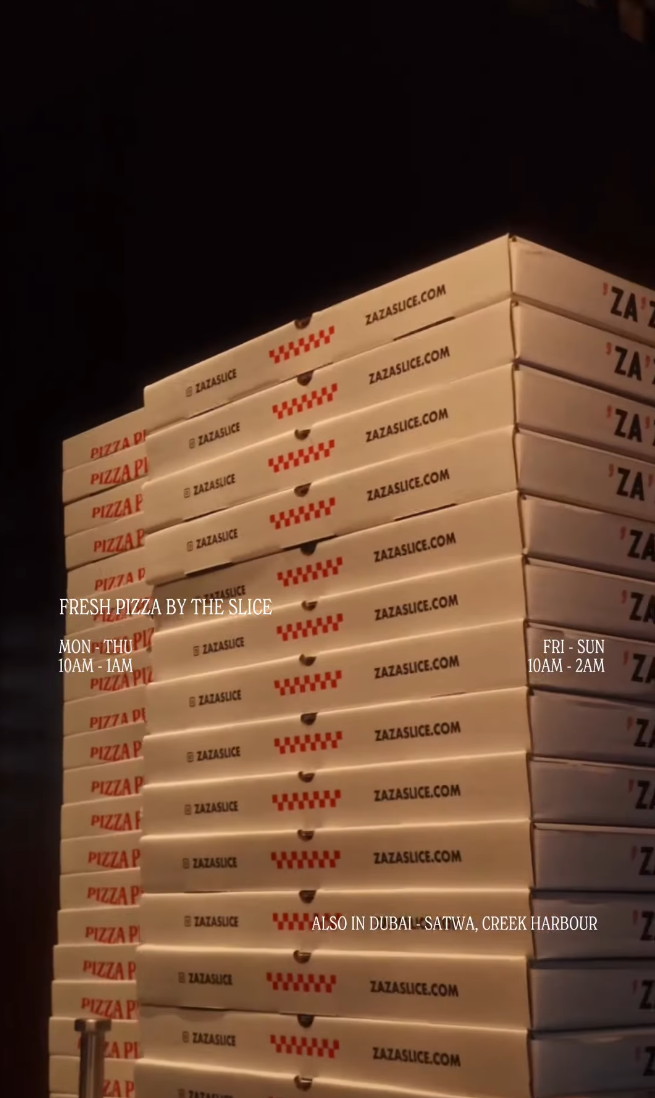 A tall stack of Za Za takeaway boxes printed with zazaslice.com