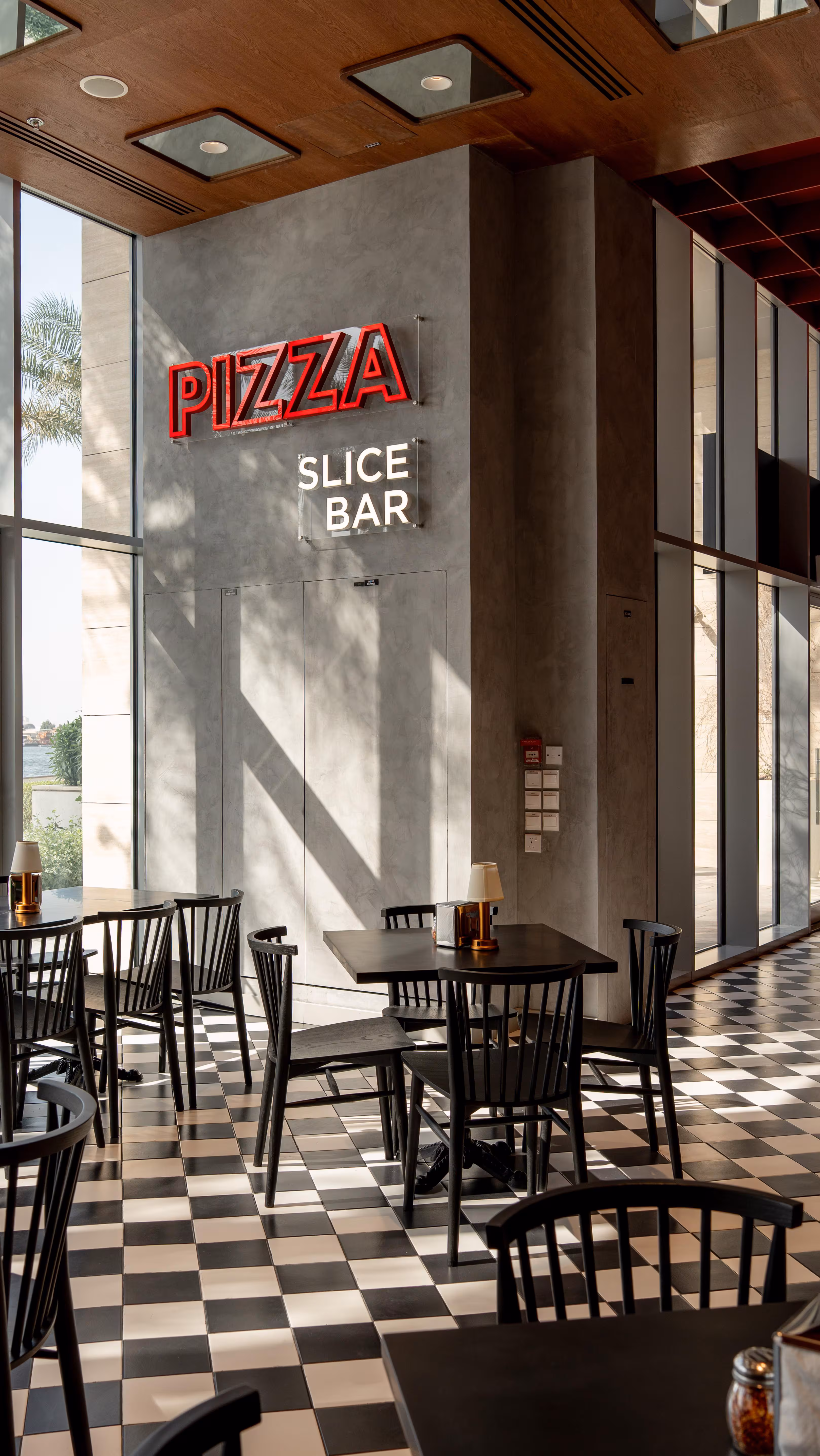 Za Za Satwa dining room with checkerboard floor, red booths and mirrored ceiling